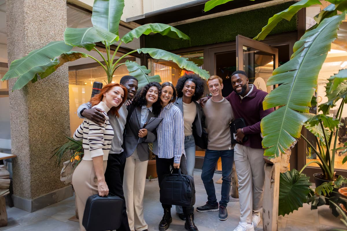 Group of diverse professionals sitting in office chairs with one woman smiling in front