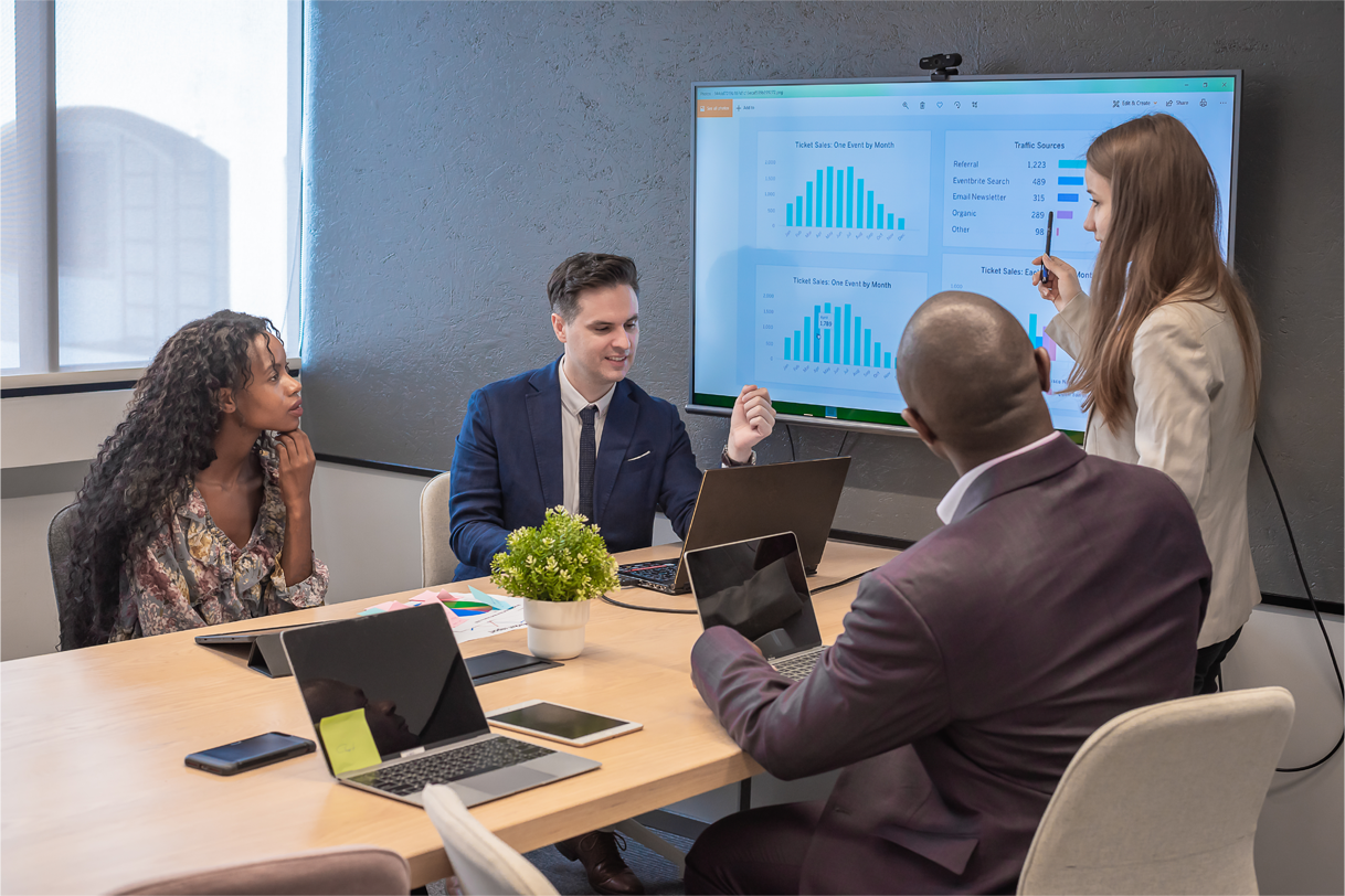 Group of diverse professionals sitting in office chairs with one woman smiling in front
