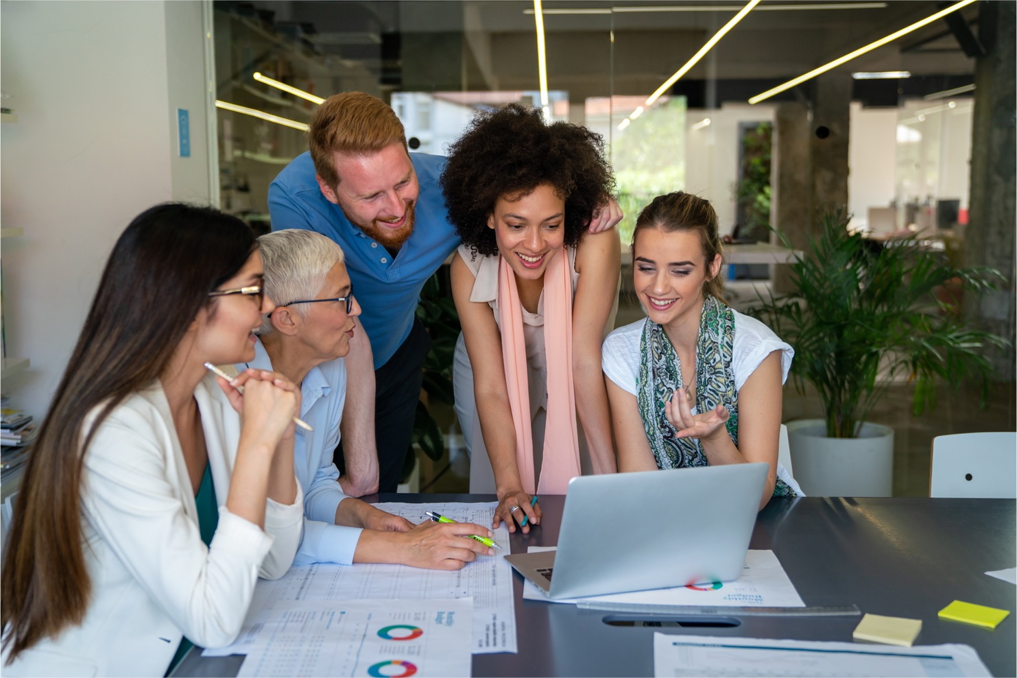 Group of diverse professionals sitting in office chairs with one woman smiling in front